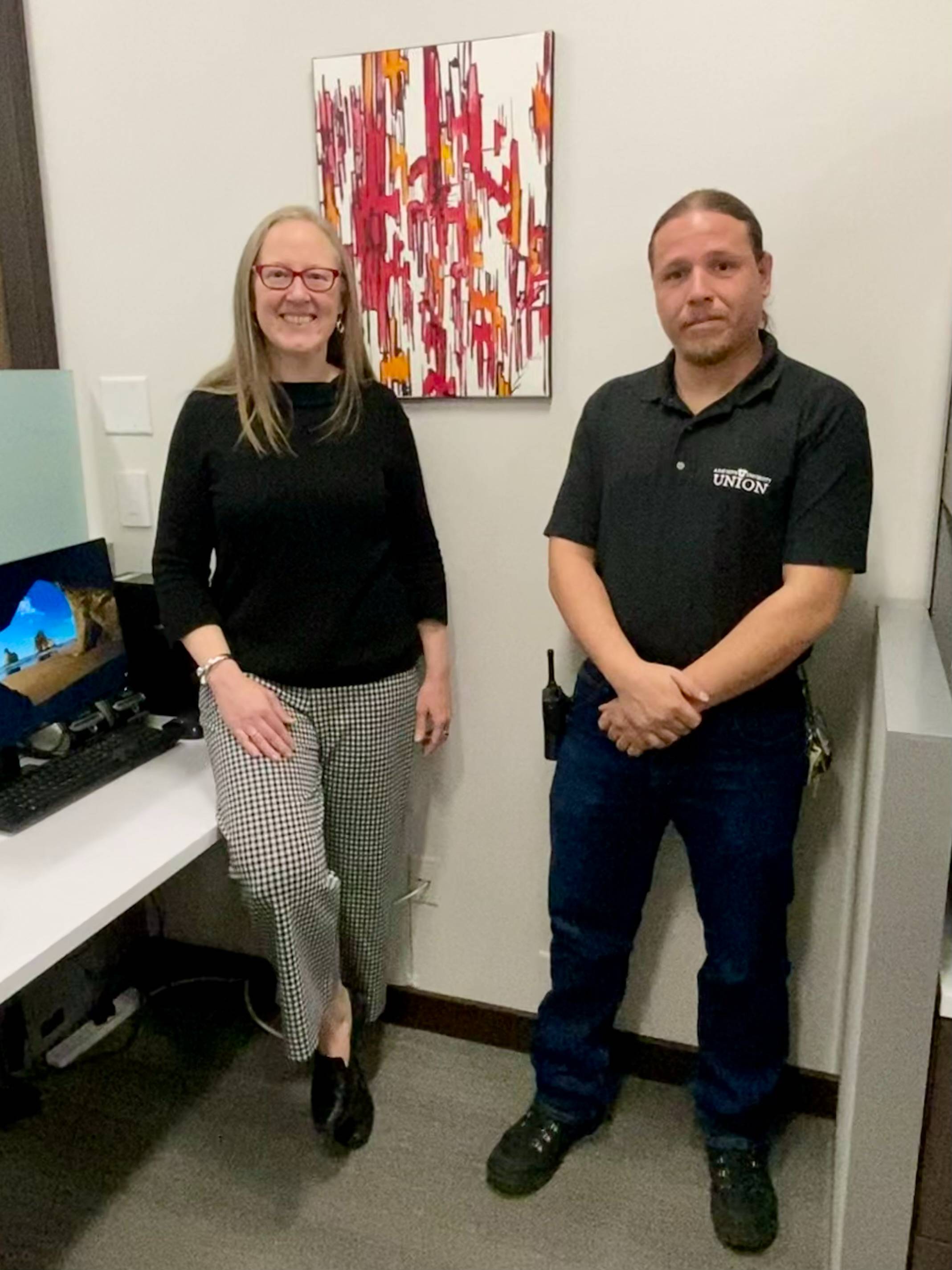 Lori McDonald and Justin Serrano pose for a photo in front of the painting.