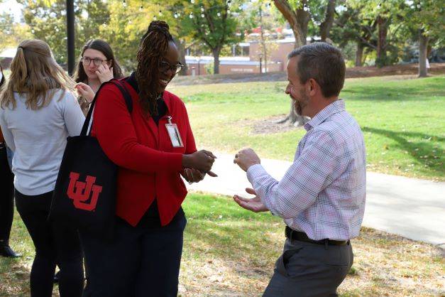 two people play rock paper scissors outside the Union.